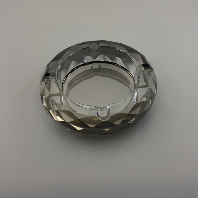Round crystal ashtray, dark faceted glass with inner metal rim