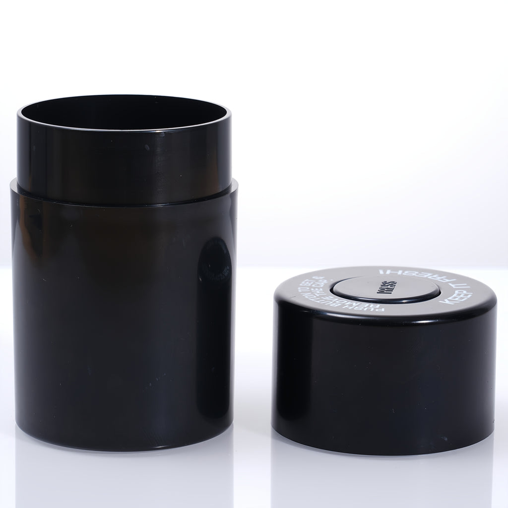 Black airtight storage jar with flip lid on a flat surface