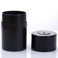 Black airtight storage jar with flip lid on a flat surface