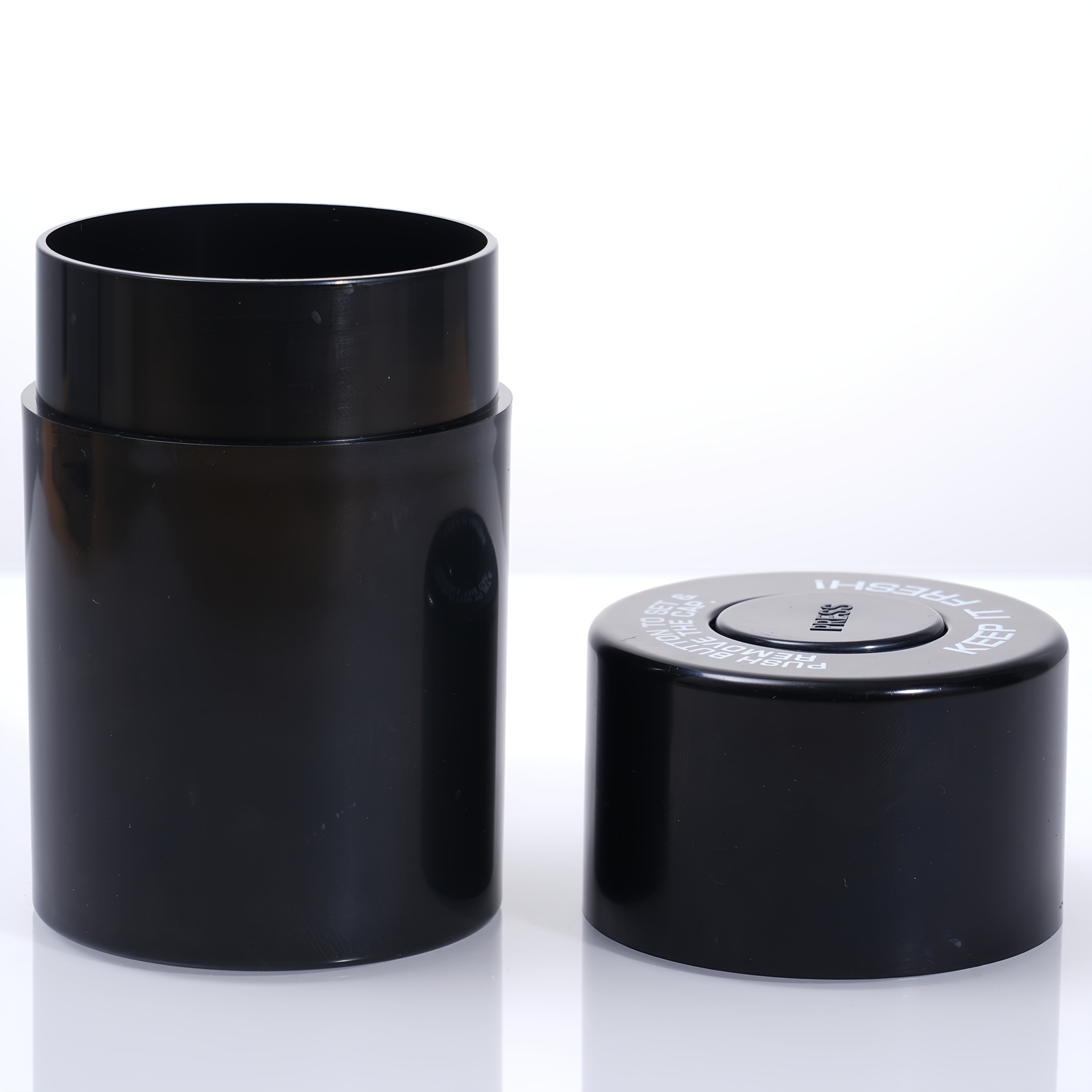 Black airtight storage jar with flip lid on a flat surface