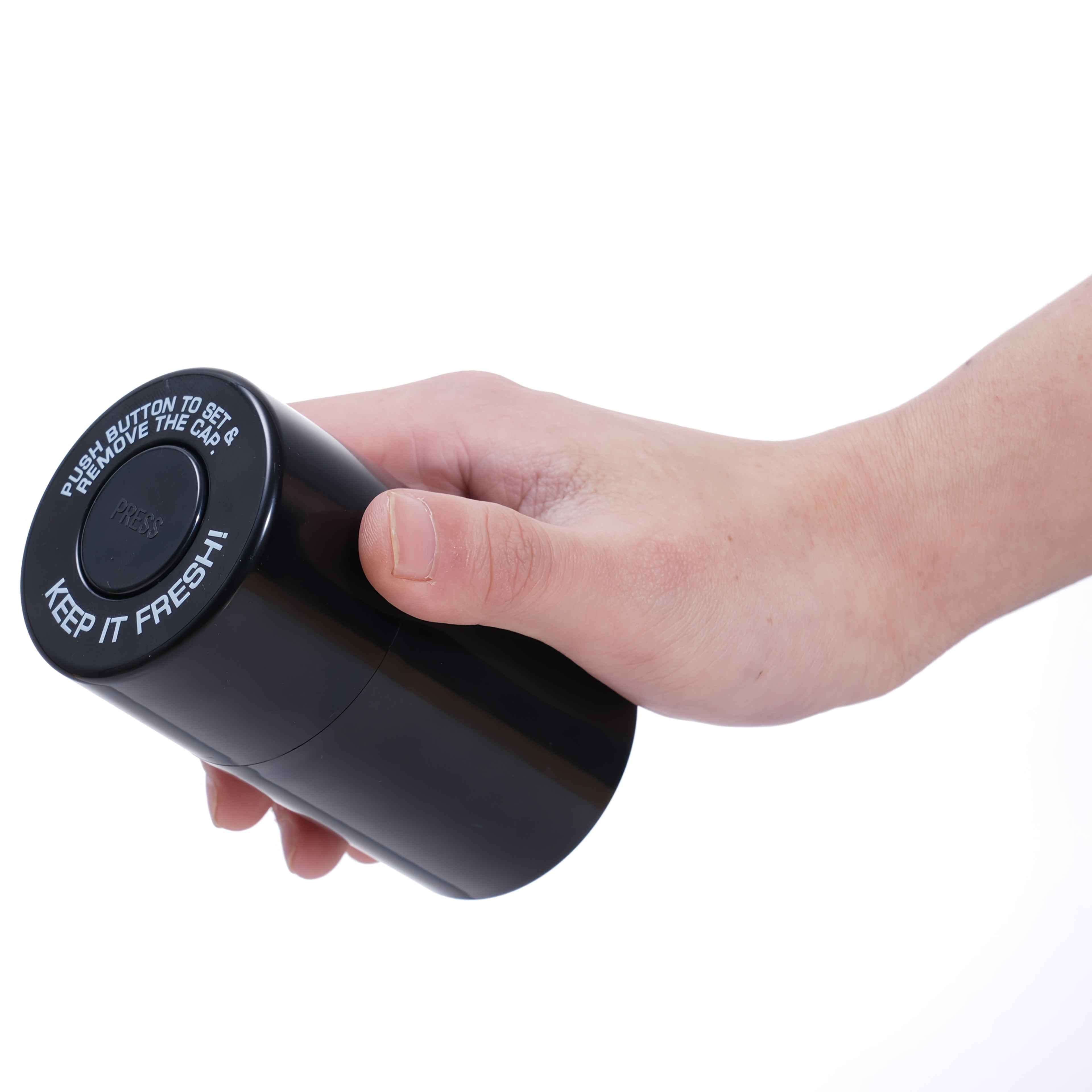 Black airtight storage jar with flip lid held in a hand