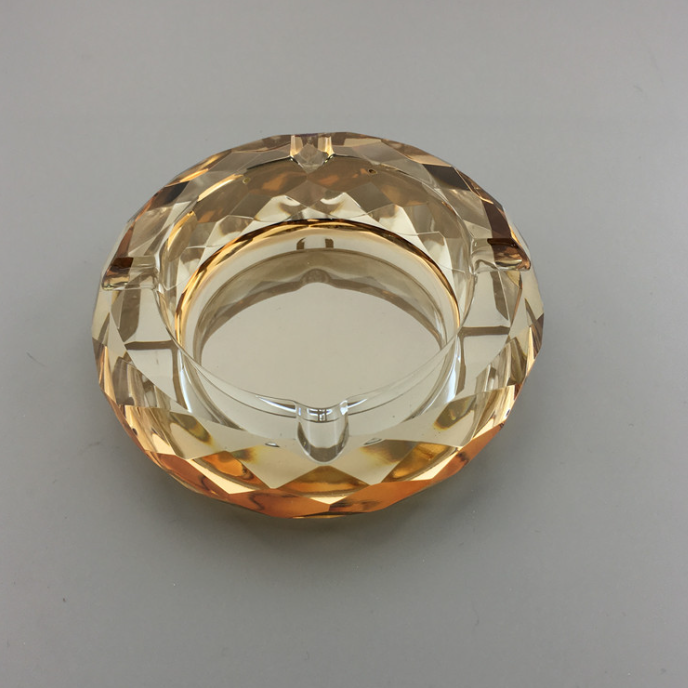 Round crystal ashtray, gold-toned faceted glass with inner metal rim