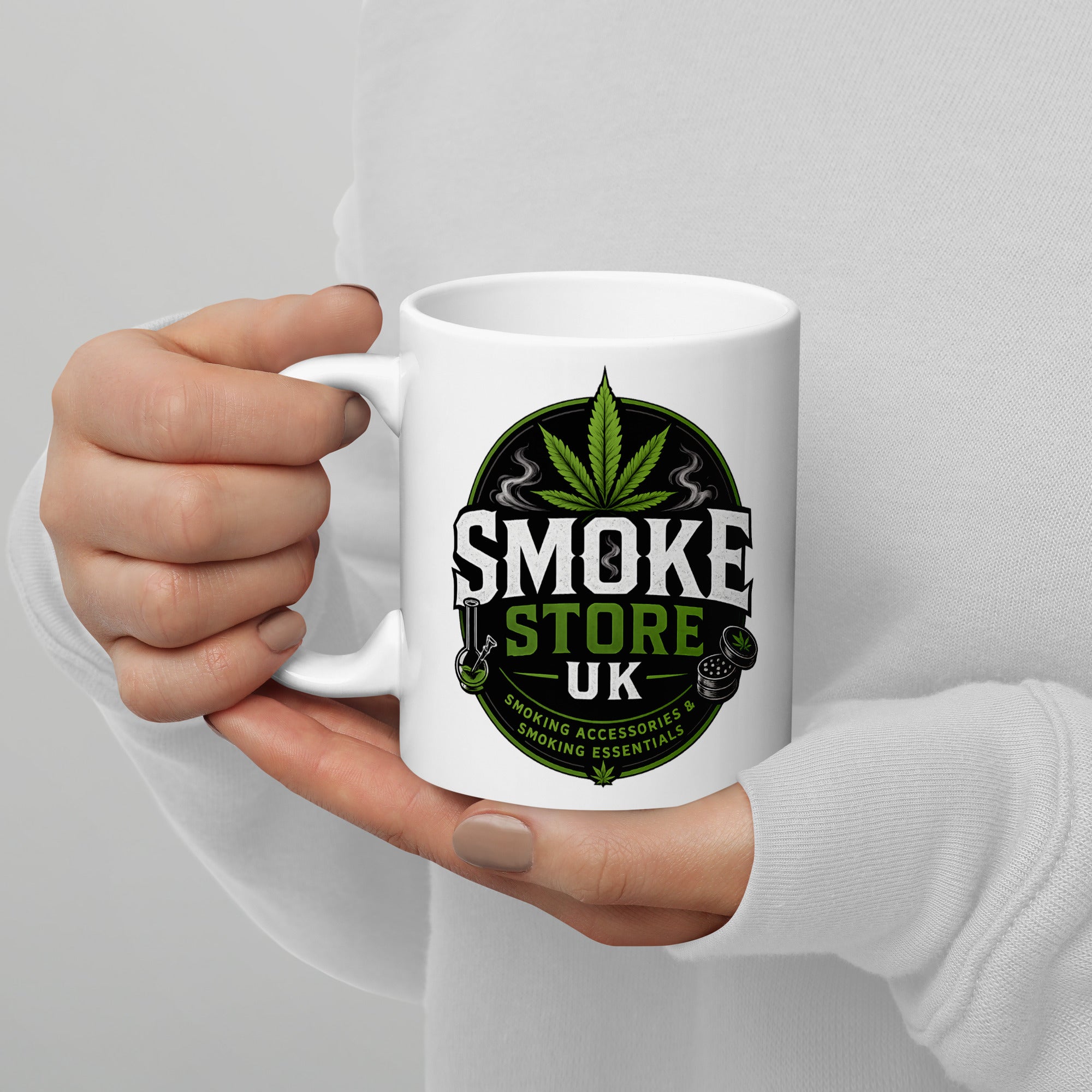 White glossy mug held in hands with Smoke Store UK logo and green leaf